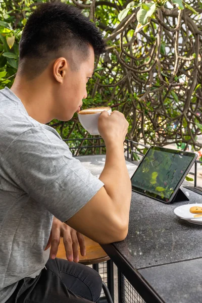 商人用平板电脑喝卡布奇诺的垂直照片 — 图库照片