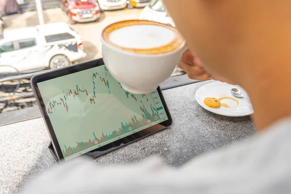 Geschäftsmann bei heißem Cappuccino und Kerzenschein auf Tablet — Stockfoto