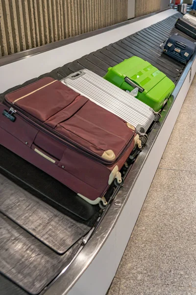 Valigie posate su nastro trasportatore al ritiro bagagli in aeroporto — Foto Stock