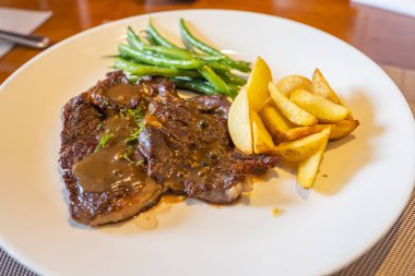 Lezzetli biftek, kızarmış patates ve yeşil fasulye.