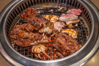 Grilled shrimps seafood and beef steak on the BBQ stove
