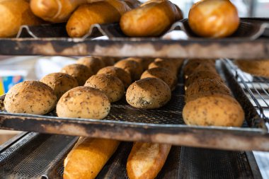 Fresh baked coffee buns and baguette breads on cooling rack