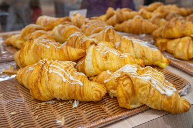 Pile of freshly baked puff croissants at pastry shop