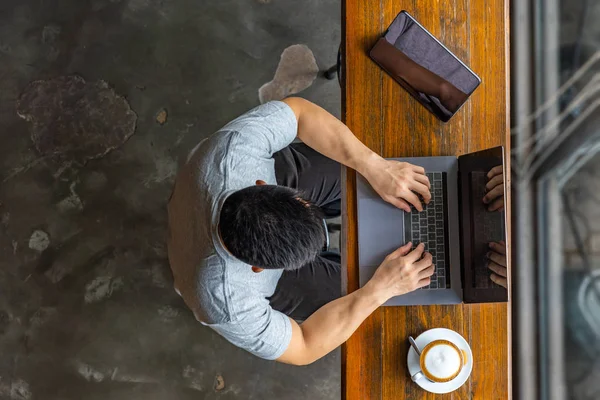 Vista superior de musculoso asiático empresario escribiendo portátil en coffeeshop — Foto de Stock