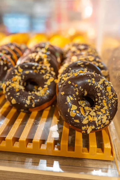 Lekkere donut met matte chocolade en bestrooi topping bij de bakkerij — Stockfoto