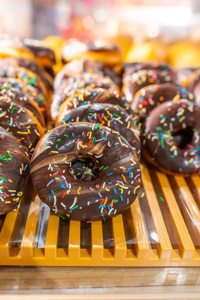 Donut belegd met matte chocolade en bestrooi de verkoop bij de bakkerij — Stockfoto