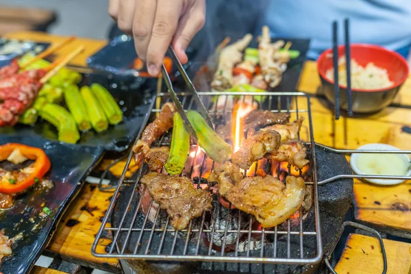 Okra de grelhamento humano e carne marinada no fogão a carvão em chamas — Fotografia de Stock