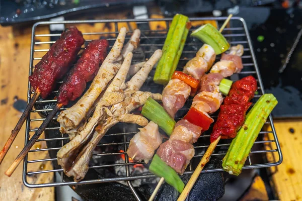 Pernas de frango e espetos de carne no aquecimento do fogão a carvão — Fotografia de Stock