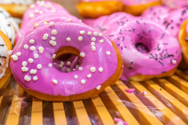 Stapel roze geglazuurde donuts te koop bij snoepwinkel — Stockfoto