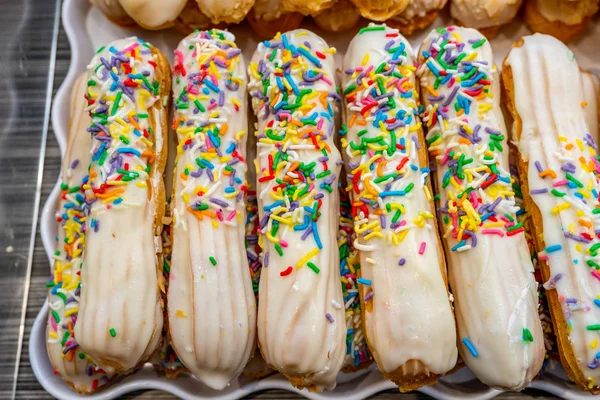 Foto da vicino di bastoncini choux cremosi e colorati — Foto Stock