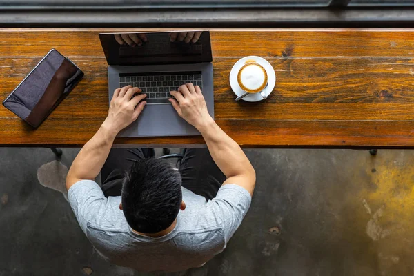 Joven freelancer asiático usando laptop y tablet en el hermoso coffeeshop — Foto de Stock