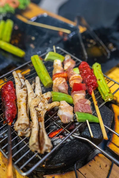 Photo verticale des brochettes et des cuisses de poulet sur poêle à charbon — Photo