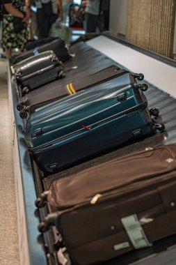 Havaalanındaki bagaj bandındaki bavulların dikey fotoğrafı.