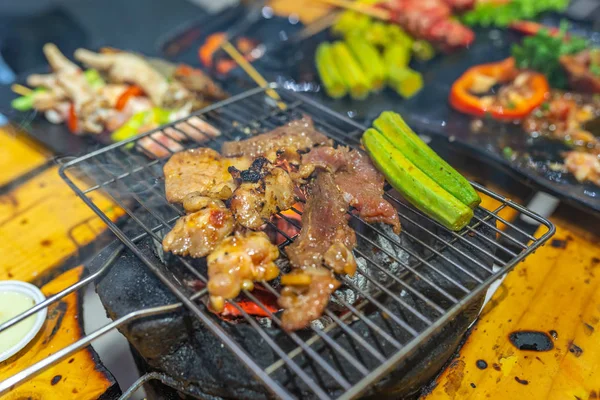 Carne grelhada e legumes de quiabo no fogão a carvão com fumaça — Fotografia de Stock