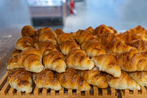 Stapel smakelijke croissants te koop bij banketbakker — Stockfoto