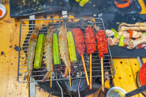 Delicioso camarão e espetos de carne no fogão a carvão defumado — Fotografia de Stock