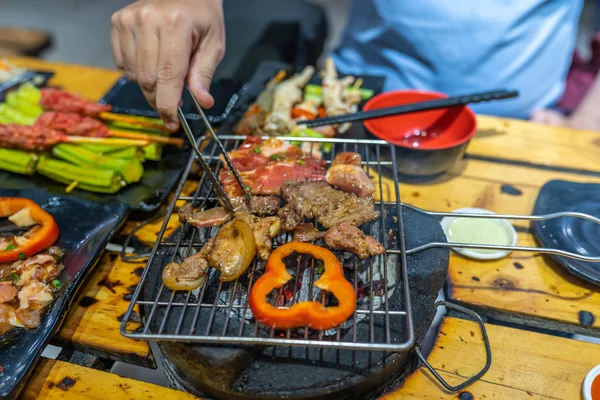 Man grillar köttskivor och paprika på kolspis — Stockfoto