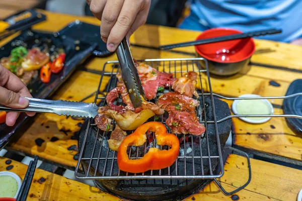 Pessoas grelhando carne e pimentão no fogão a carvão — Fotografia de Stock