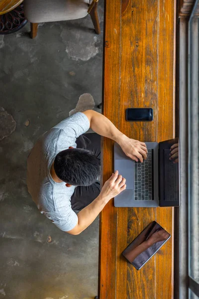 Vista superior del freelancer asiático usando el ordenador portátil en la mesa de madera — Foto de Stock