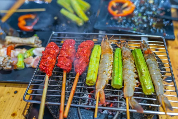 Espetos de camarão e palitos de carne no fogão a carvão de churrasco — Fotografia de Stock