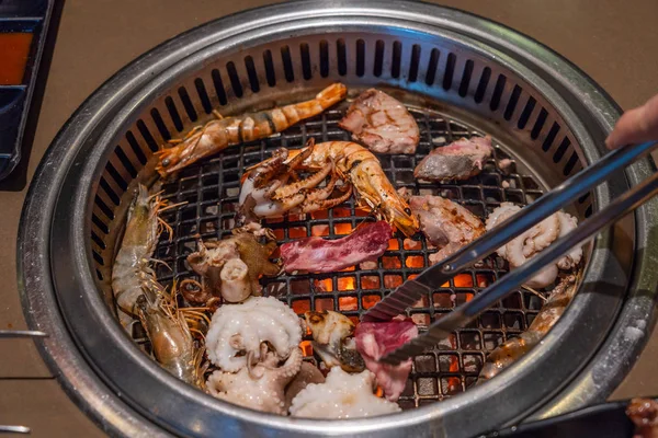 Camarones, pulpo, calamares a la parrilla en una estufa caliente — Foto de Stock