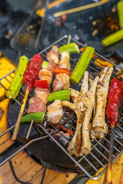 Espetos de porco grelhados, perna de frango e legumes no fogão a carvão — Fotografia de Stock