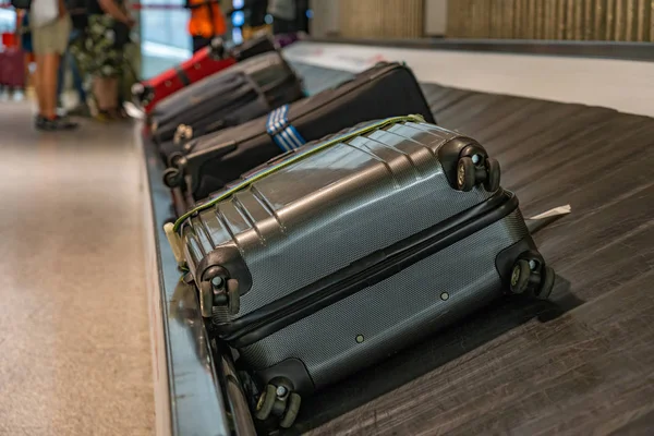 Suitcases on luggage conveyor belt at baggage claim waiting lounge