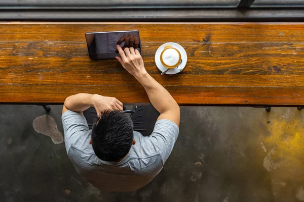 Vista superior de freelancer asiático usando tableta en coffeeshop rústico — Foto de Stock