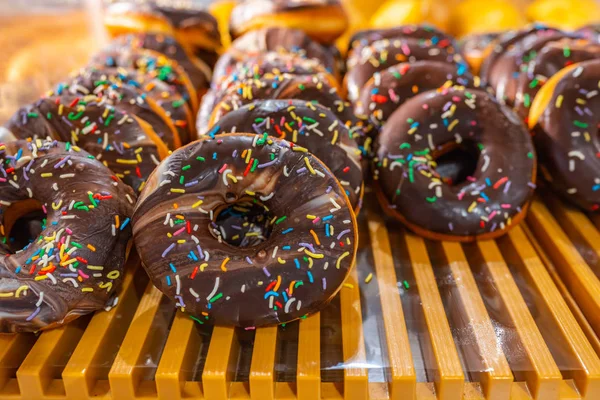 Heerlijke matte chocolade donut weergegeven op plank in banketbakkerij — Stockfoto