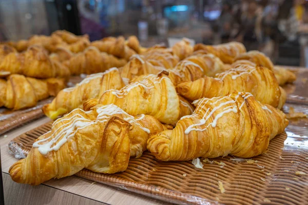 Croissants hinchados con salsa de queso crema en la parte superior en bakeshop — Foto de Stock