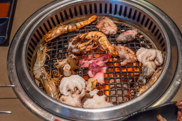 Camarones, pulpo, calamares a la parrilla en una estufa caliente — Foto de Stock