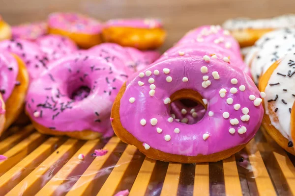Roze geglazuurde donut belegd met witte chocolade chips bij de bakkerij — Stockfoto