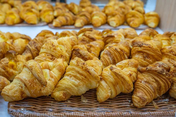 Montón de croissants hinchados en estante para la venta en pastelería — Foto de Stock