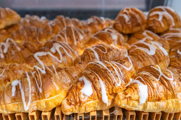 Número de deliciosos cruasanes de mantequilla horneada fresca en la pastelería — Foto de Stock