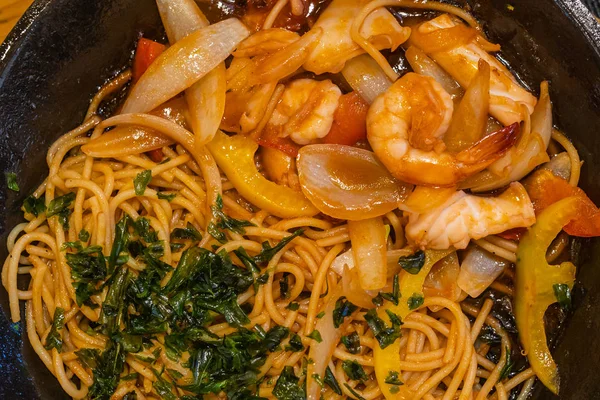 Вкусные спагетти с креветками и луком подаются с нарезанной петрушкой — стоковое фото