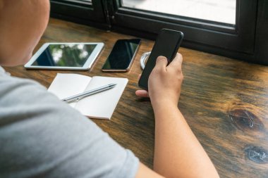 Kırsal ahşap masada cep telefonu kullanan işadamının arka görüntüsü