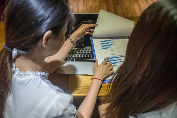 Two female accountants working on chart document at business office — ストック写真