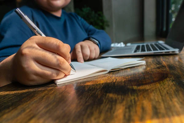 Donna mano tenendosi per mano e scrivendo taccuino mentre si lavora — Foto Stock