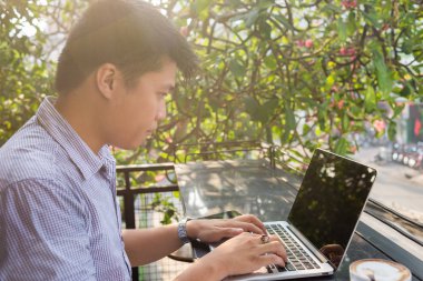 Dizüstü bilgisayarda çalışan Asyalı adam