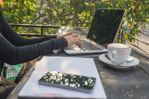 Жінка пише нотатки в сонячний ранок — стокове фото