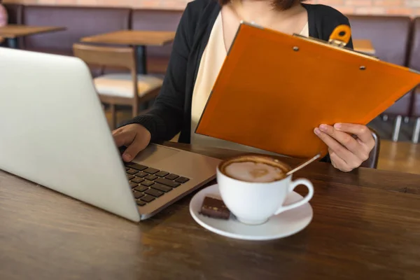 Joven mujer de negocios leyendo informes financieros, trabajando en el ordenador portátil — Foto de Stock