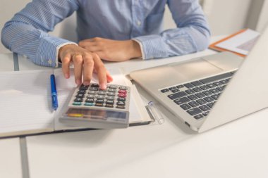 İş odasında hesap makinesi kullanan Asyalı bir ofis kadını.