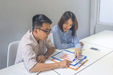 Asyalı iş adamları mali raporları okuyup tartışıyor