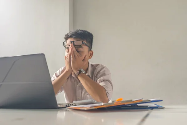 Уставший человек в офисе закрывает глаза, думая о бизнесе — стоковое фото