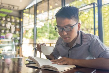 Asyalı öğrenci kahveden ve kitap okumaktan hoşlanıyor