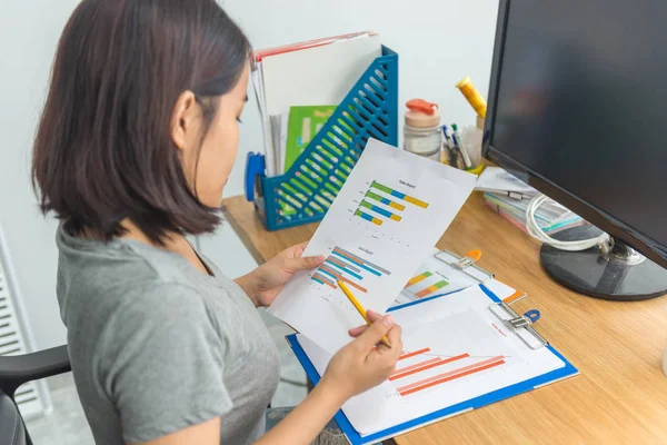 カジュアルな摩耗の若いアジアのオフィスの女性財務チャートデータを分析 — ストック写真