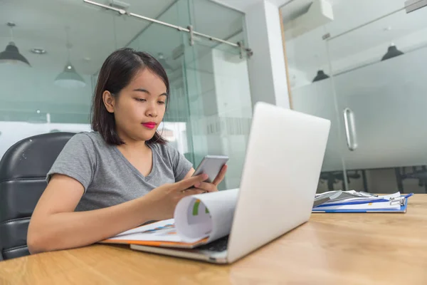 Chica asiática moderna usando smartphone en la oficina de negocios — Foto de Stock