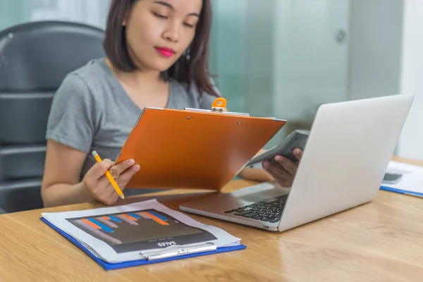 Joven mujer de negocios asiática leyendo informes financieros — Foto de Stock