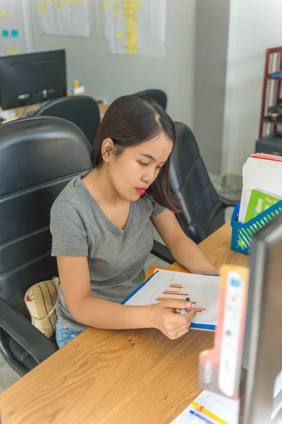 Jóvenes empleados de negocios asiáticos leyendo informes financieros — Foto de Stock