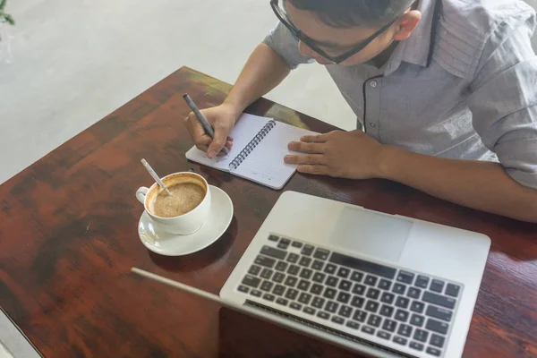 Joven estudiante asiático escribiendo ideas importantes en la nota — Foto de Stock